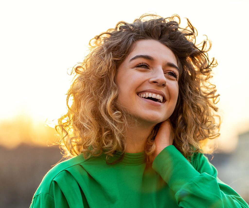 Portrait of young woman with curly hair in the city.