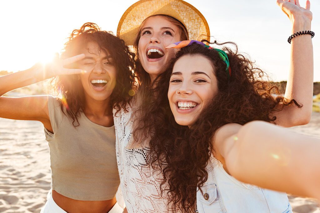 Three cheerful girls friends on the beach