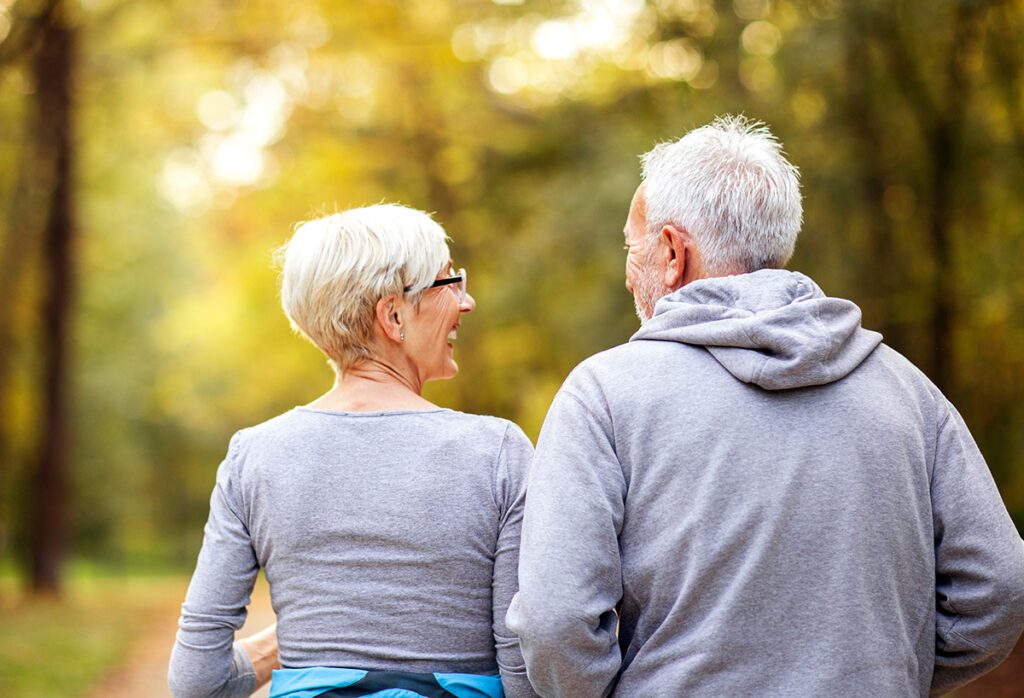 Elderly couple walking in the woods.