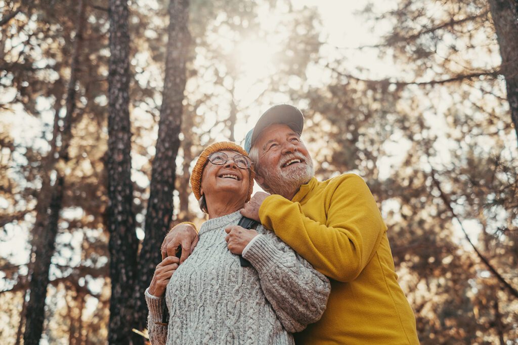 Middle age cheerful people smiling and looking at the the trees.