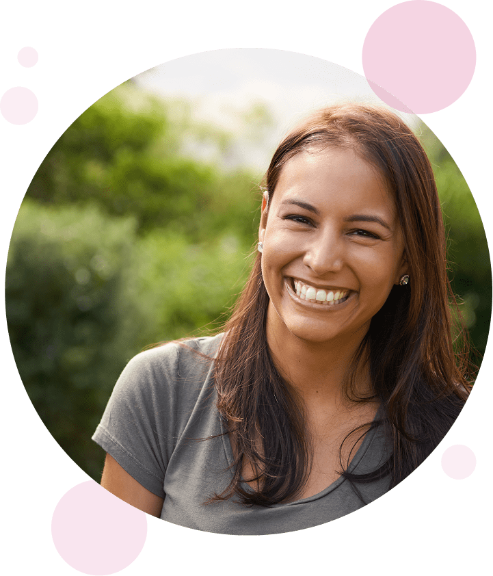 Women smiling in portrait with trees in the background.