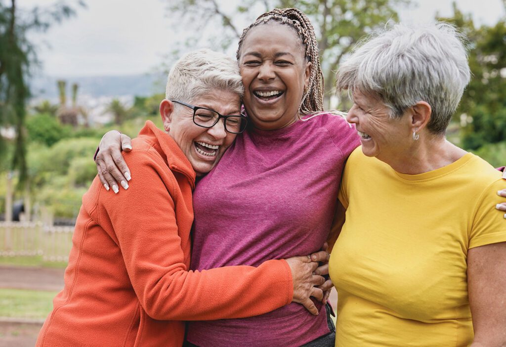 Women laughing and holding each other.