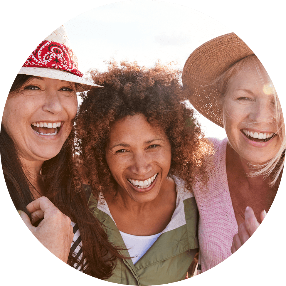 Older women smiling and laughing with sunshine in the background.