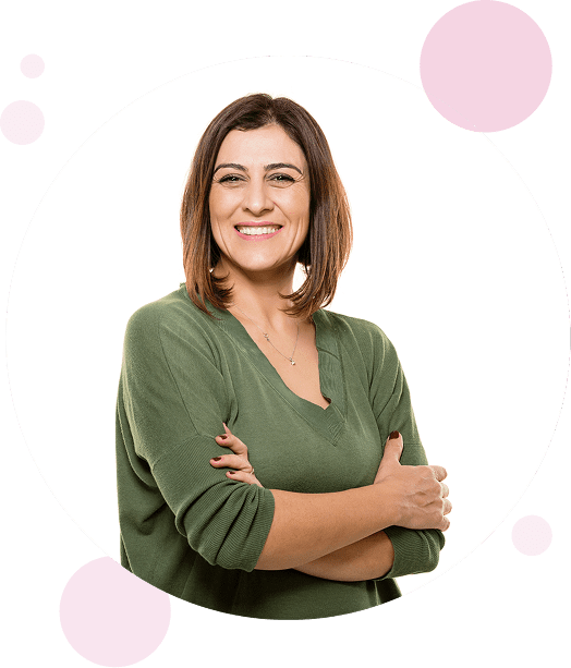 Women in her 40's smiling for photo and holding her arms.