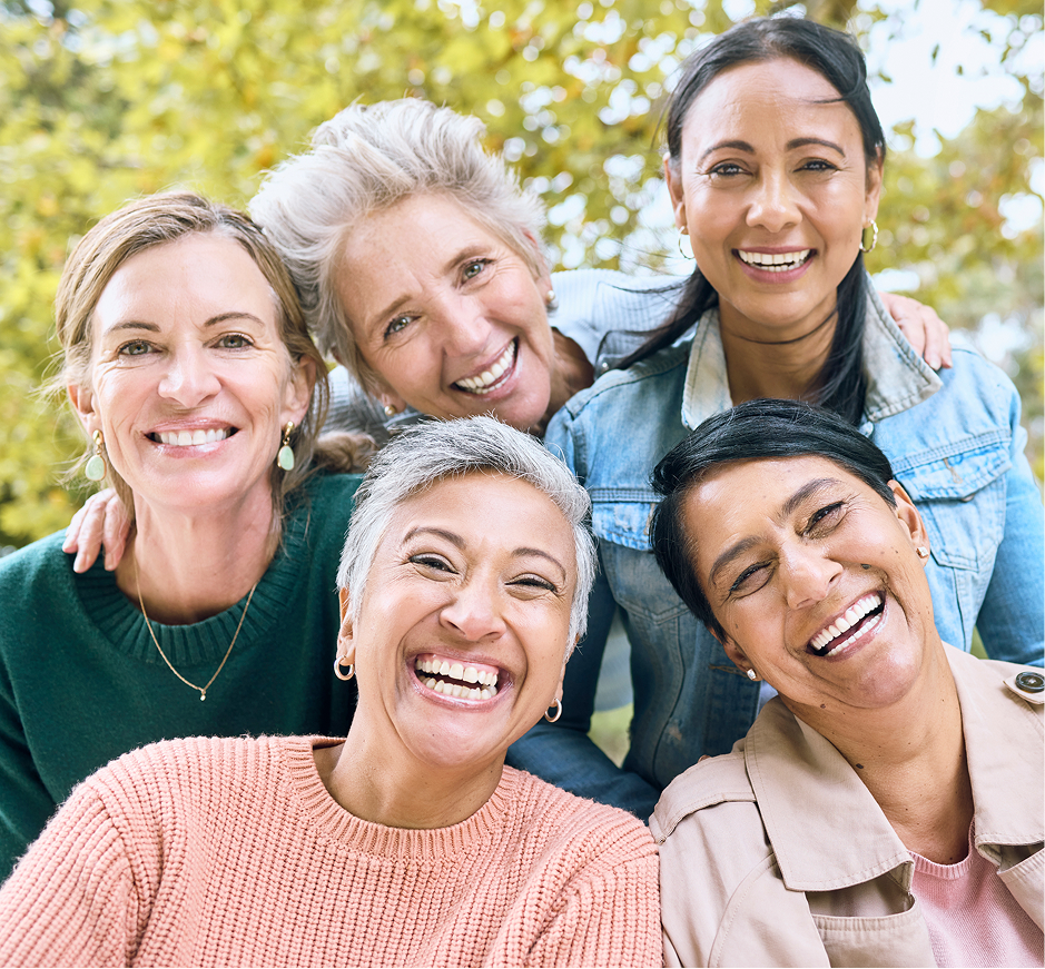 Women smiling for a picture as a group together.
