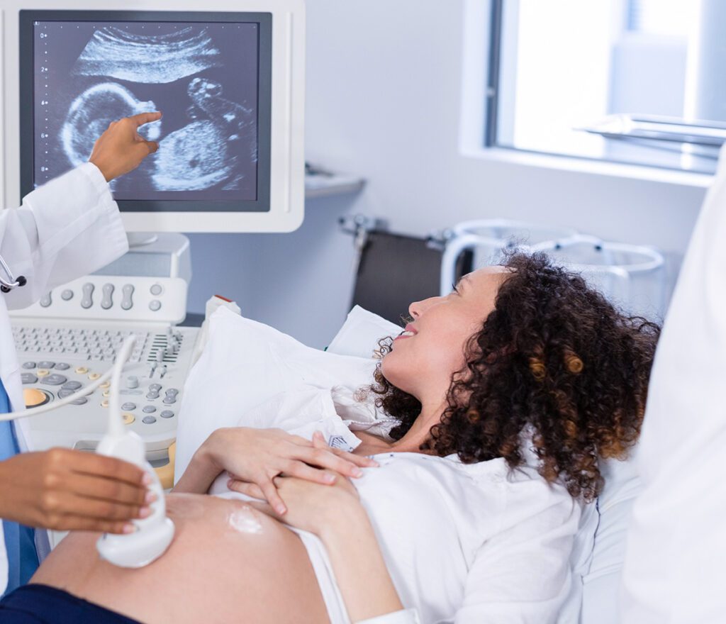 Doctor doing ultrasound scan for pregnant woman.