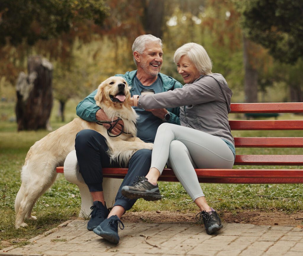 Older couple with their dog in the park.