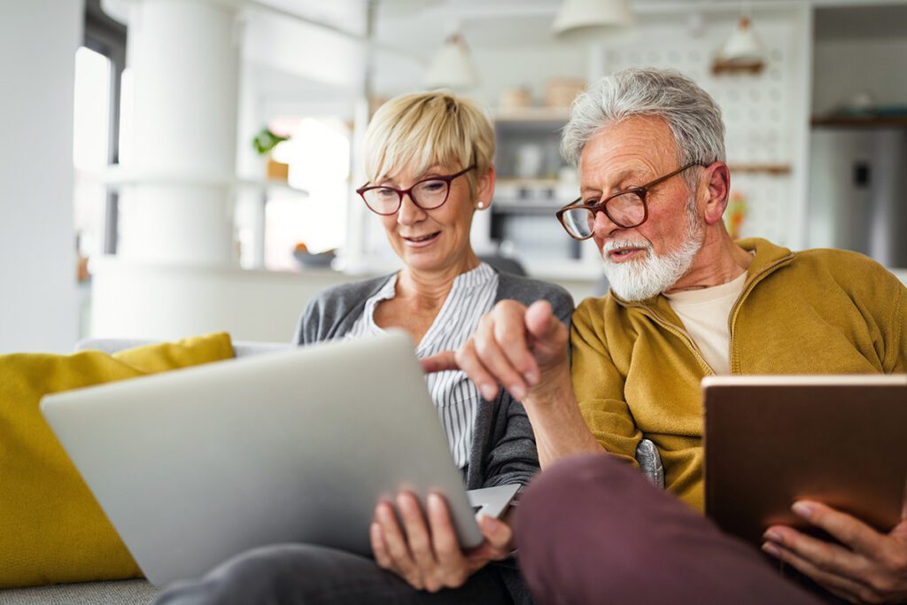 elderly couple paying their bill on a tablet