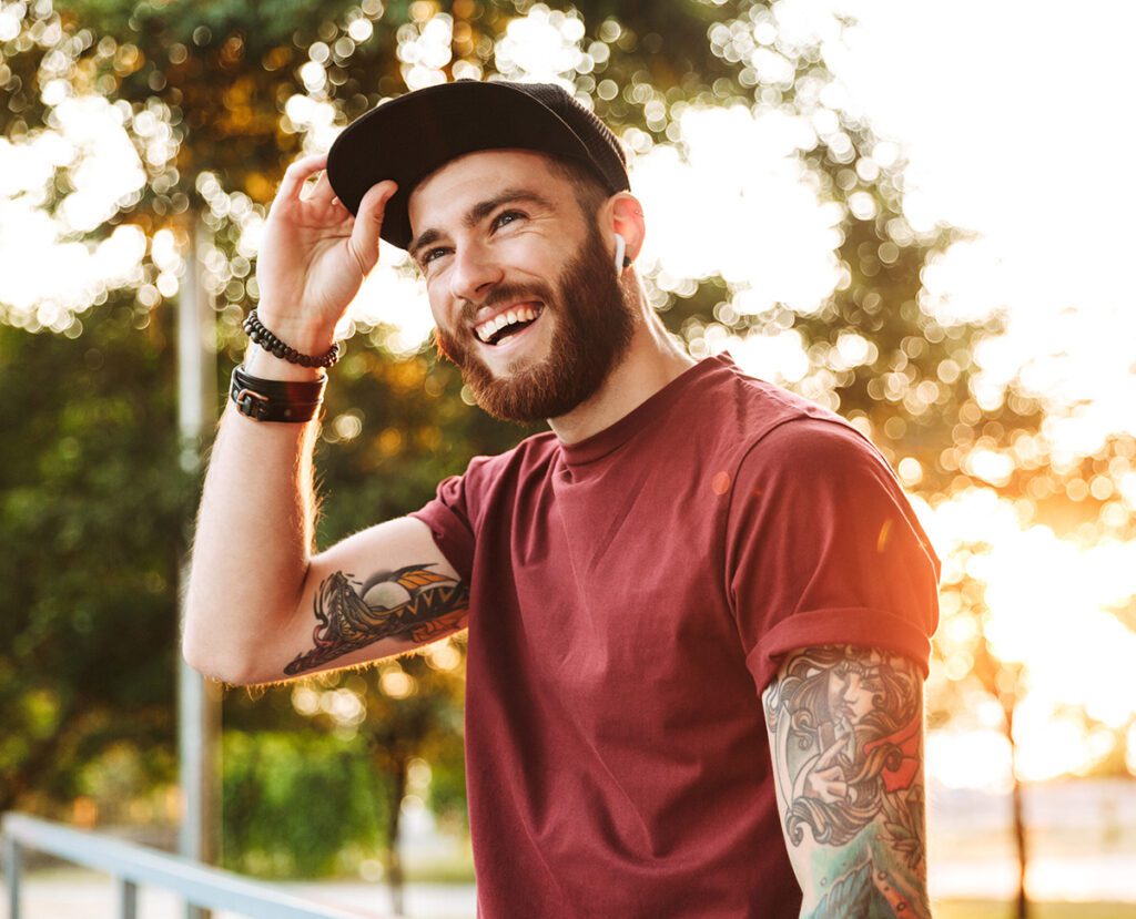Young man smiling while outside on a sunny day.