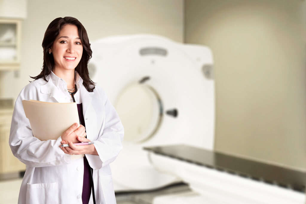 radiologist next to ct scan machine with chart in hand