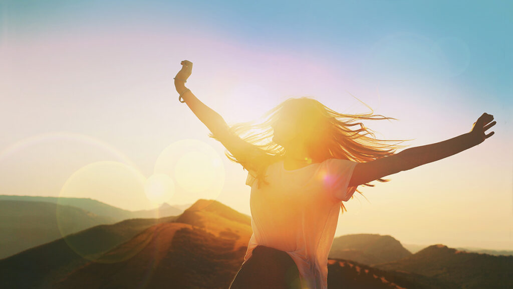 women jumping with the sunset in the background